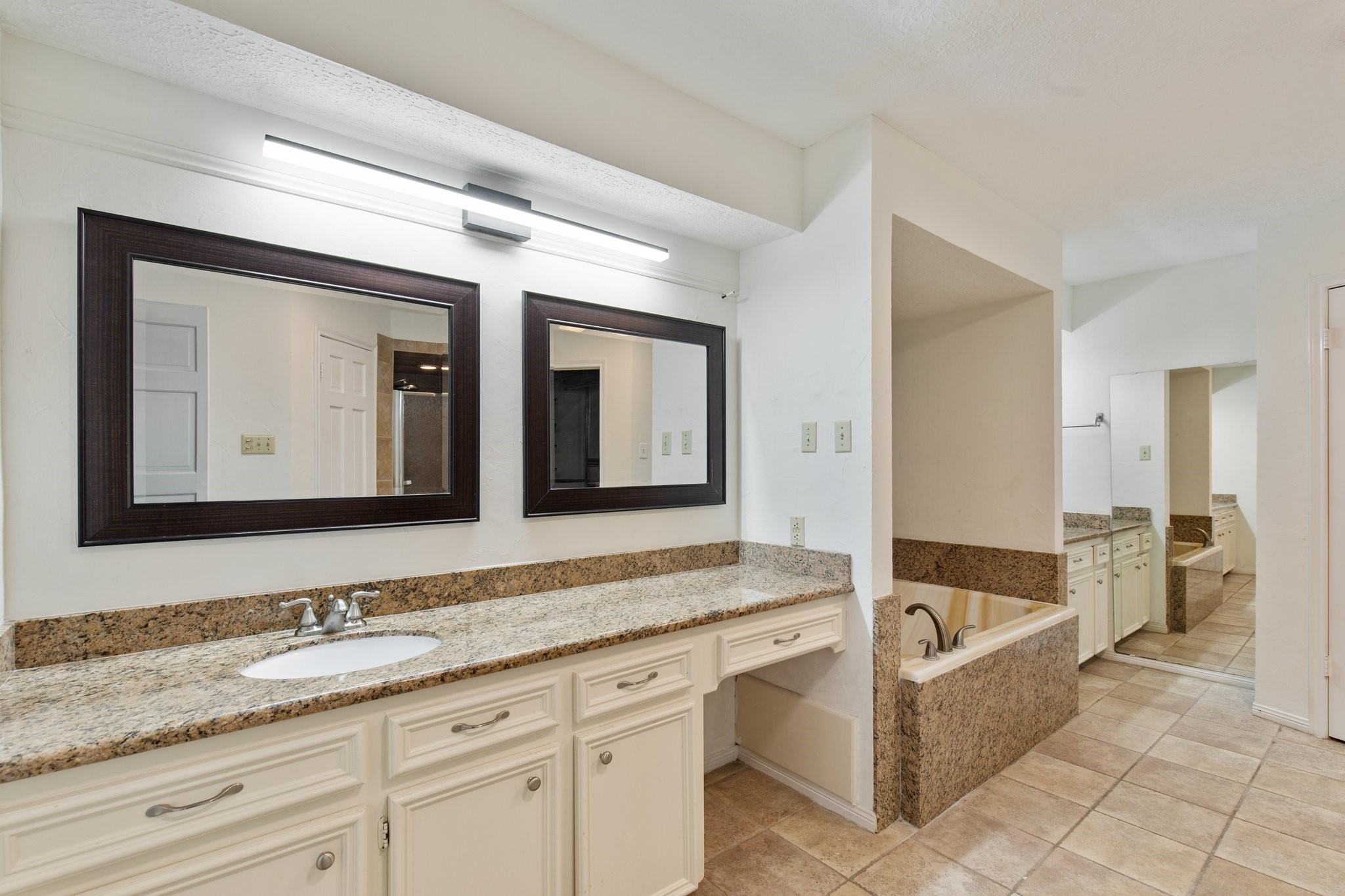 17902 Fernbluff Drive Spring, TX 77379 - Photo 28 of 38 a bathroom with a granite countertop tub sink and mirror