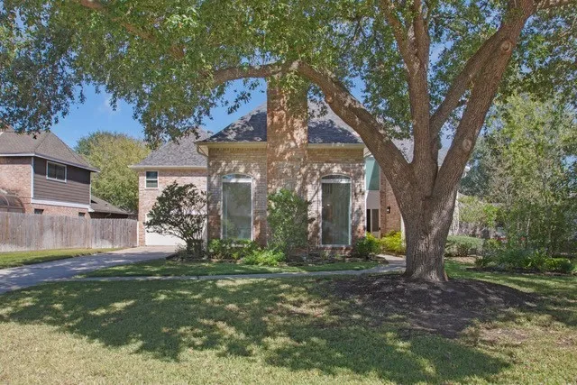 a view of a house with garden and trees