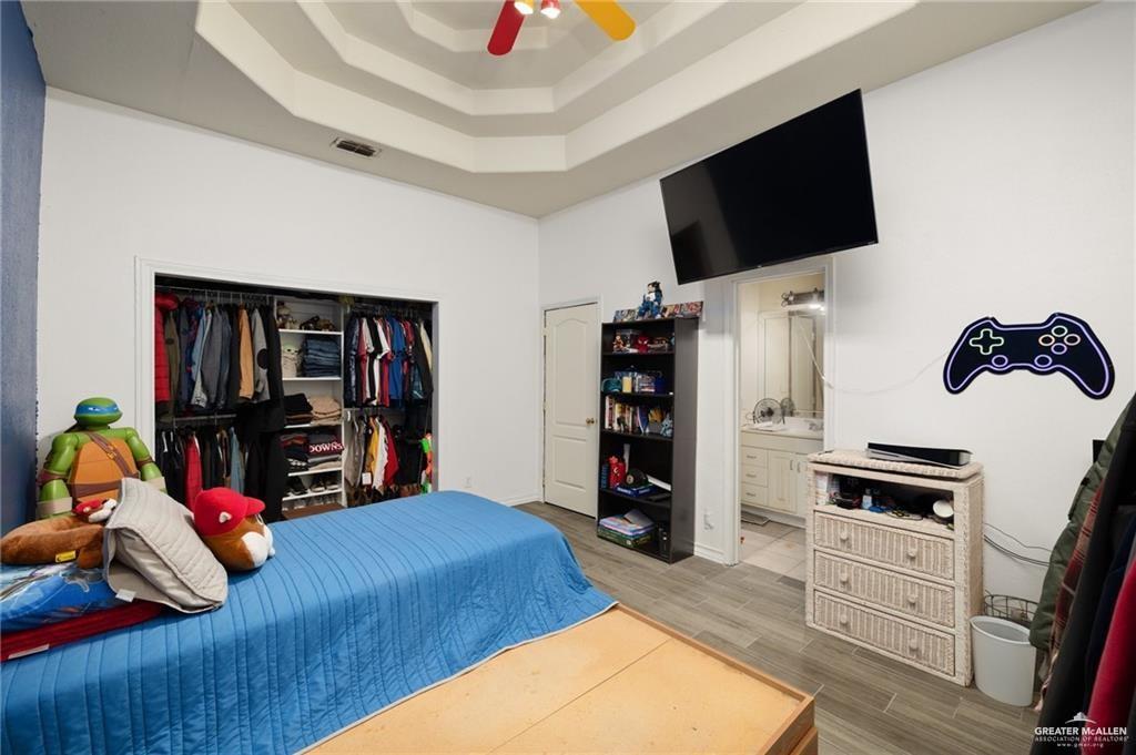 4523 South Tower Road Edinburg, TX 78542 - Photo 26 of 34 a bedroom with a bed a flat screen tv and a book shelf