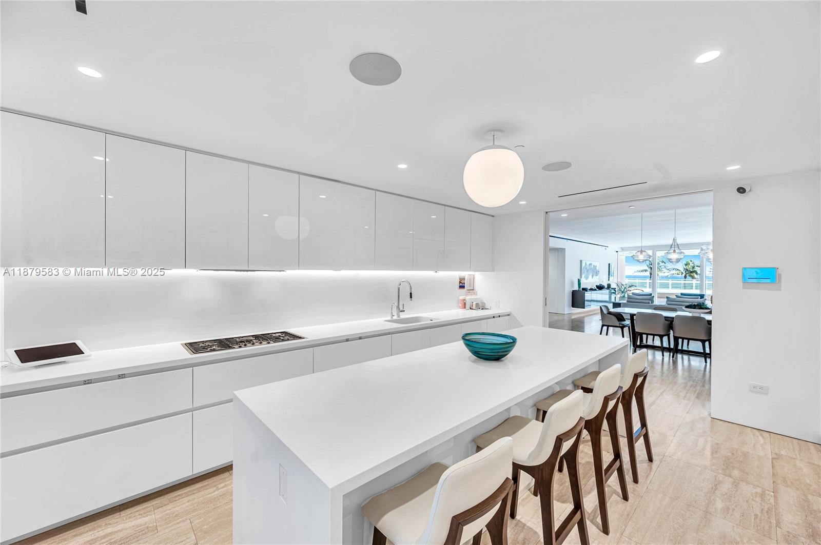 9001 Collins Avenue, Unit S201 Surfside, FL 33154 - Photo 20 of 44 a kitchen with a table and chairs in it