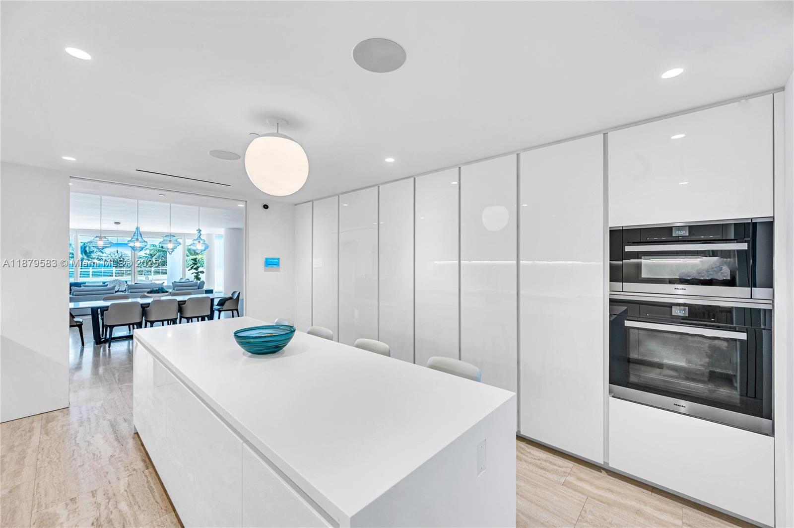 9001 Collins Avenue, Unit S201 Surfside, FL 33154 - Photo 21 of 44 a kitchen with a table and chairs
