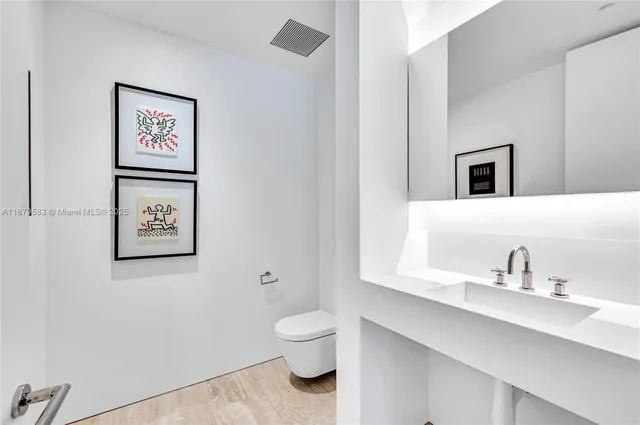 a bathroom with a toilet a sink and mirror