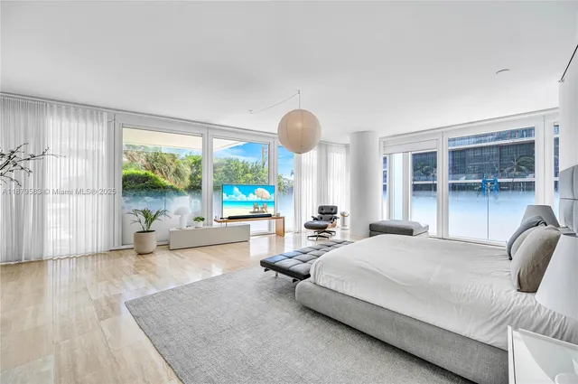 a bedroom with furniture and a large window