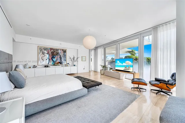 a bedroom with furniture and a large window