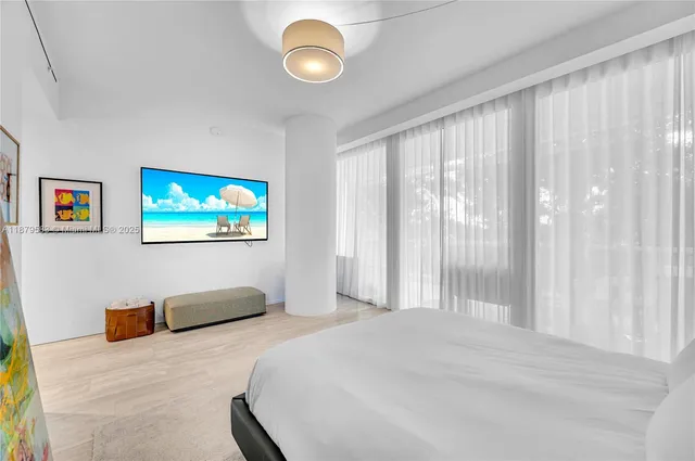 a bedroom with a large bed and a chandelier