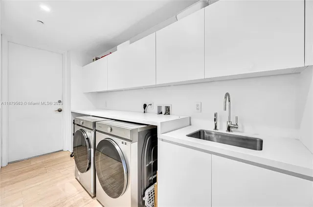 a utility room with sink dryer and washer