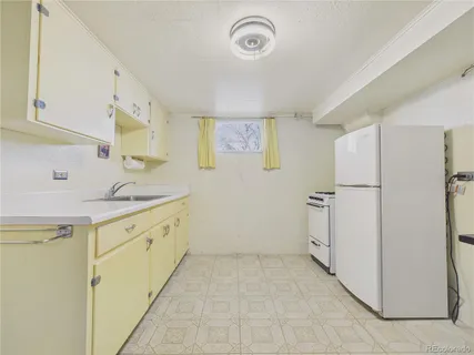 a kitchen with a refrigerator sink and cabinets