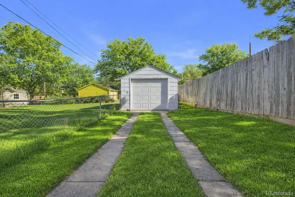 a view of a house with a big yard plants and large trees