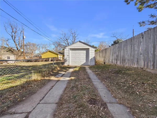 a view of a house with a yard and wooden fence