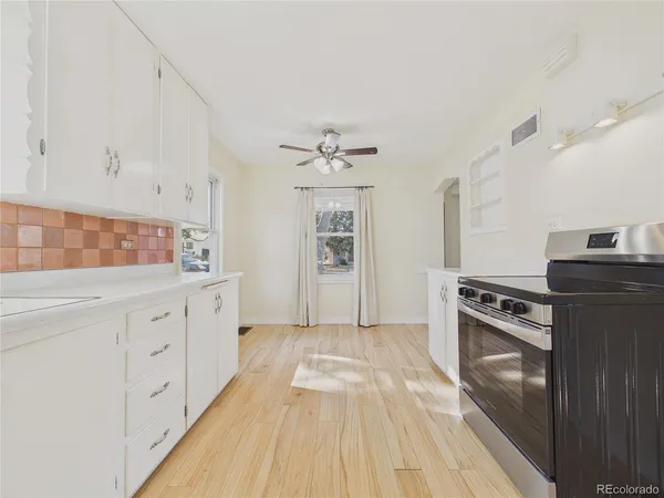 a kitchen with granite countertop white cabinets and stainless steel appliances