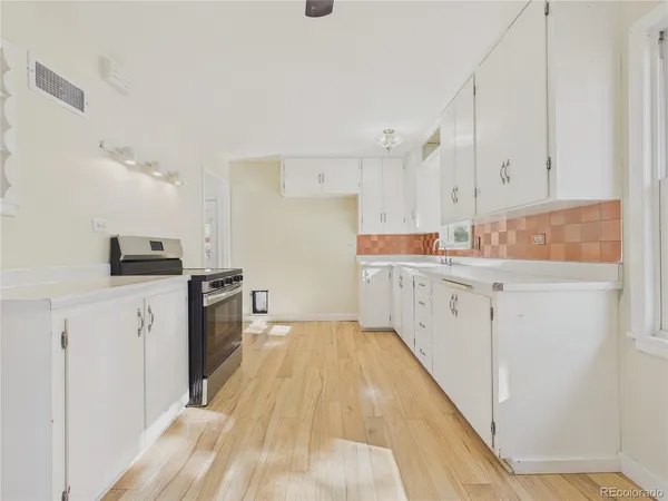 a kitchen with white cabinets sink and stainless steel appliances