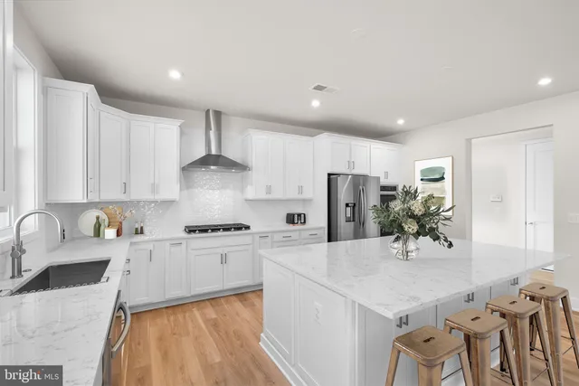 a kitchen with granite countertop a sink stainless steel appliances and cabinets