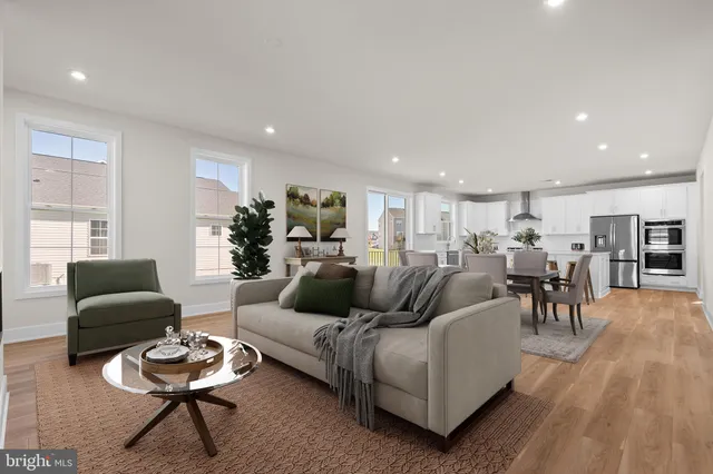 a living room with furniture rug and kitchen view