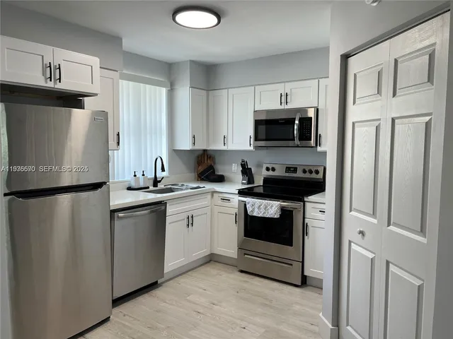 a kitchen with stainless steel appliances a refrigerator stove and microwave