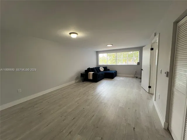 a view of a livingroom with furniture hardwood floor and a window