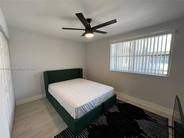 a bedroom with a bed and a ceiling fan