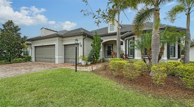 a view of a house with a yard and palm trees