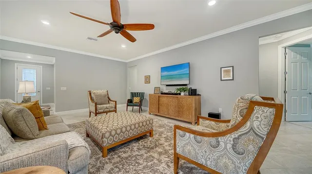 a living room with furniture a ceiling fan and a rug