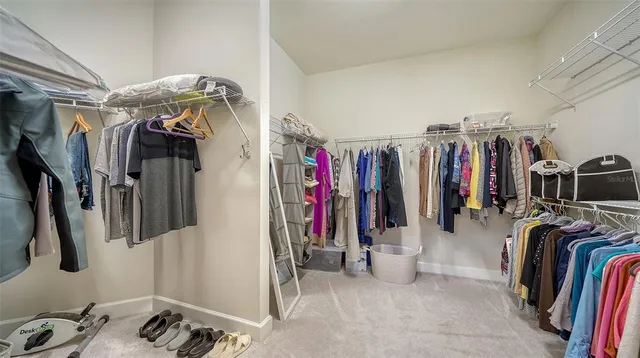 a view of walk in closet with clothes and shoes