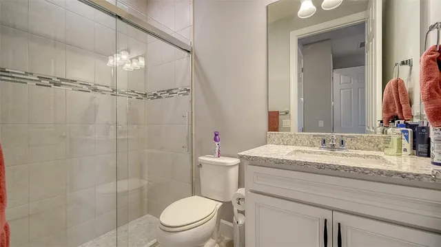 a bathroom with a granite countertop sink toilet a mirror and shower