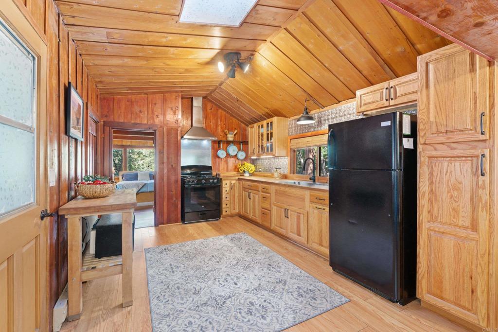 22194 Crestline Road Palomar Mountain, CA 92060 - Photo 16 of 75 a kitchen with stainless steel appliances granite countertop a refrigerator a sink and white cabinets