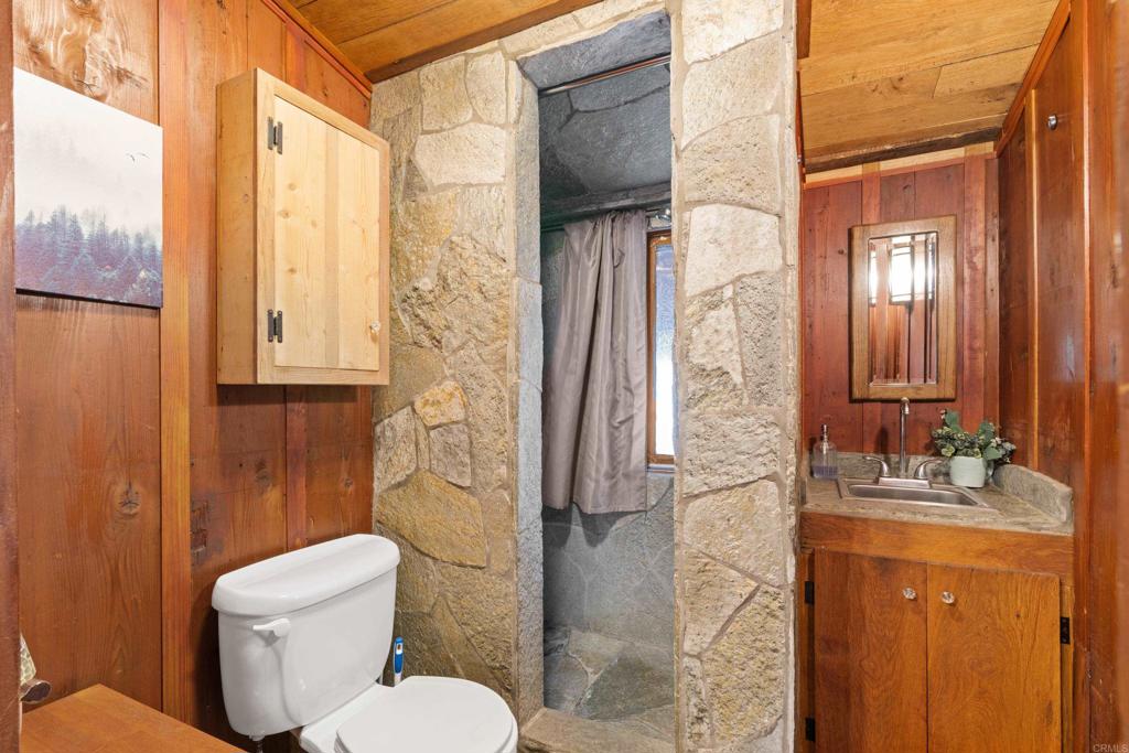 22194 Crestline Road Palomar Mountain, CA 92060 - Photo 19 of 75 a bathroom with a granite countertop sink toilet and shower