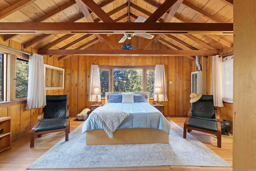 22194 Crestline Road Palomar Mountain, CA 92060 - Photo 20 of 75 a living room with a bed furniture and a chandelier