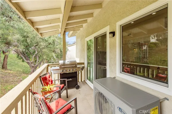 a balcony of a house with wooden floor and outdoor seating
