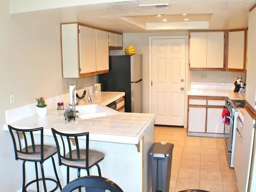 a kitchen with a table chairs sink and cabinets