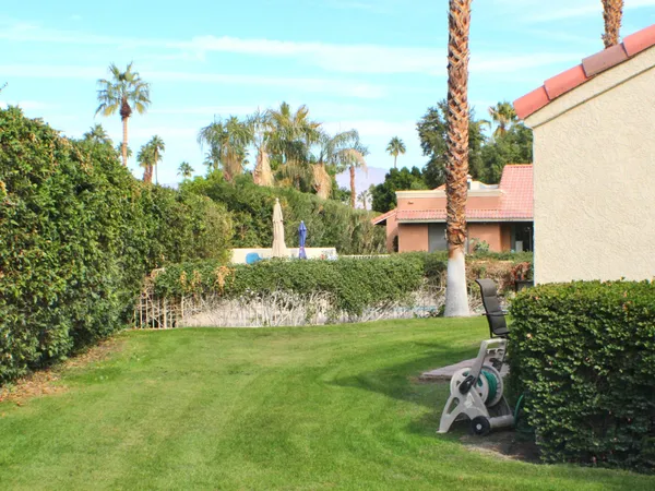 a view of a white house with a yard and plants