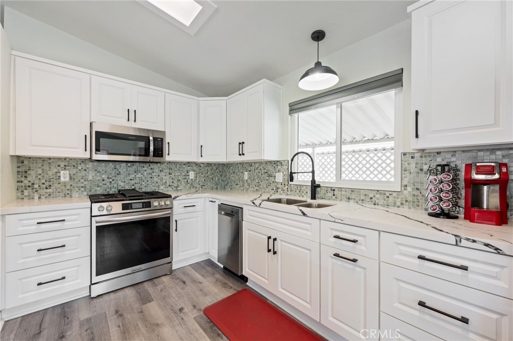 65 Hummingbird Lane Oceanside, CA 92057 - Photo 15 of 38 a kitchen with granite countertop white cabinets white stainless steel appliances and sink