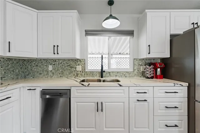 a kitchen with cabinets appliances a sink and a window