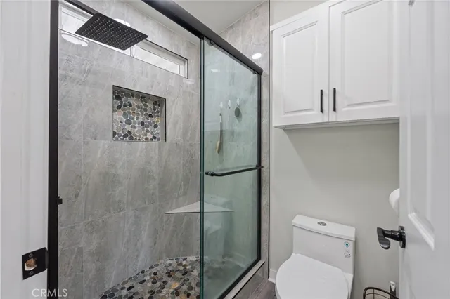a bathroom with a toilet and a shower