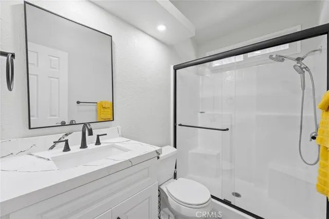 a bathroom with a granite countertop sink toilet and shower