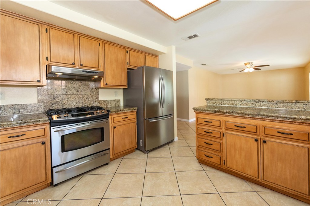 39203 Laurel Leaf Drive Murrieta, CA 92563 - Photo 14 of 59 a kitchen with stainless steel appliances granite countertop a stove a sink and a refrigerator