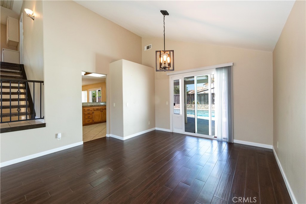 39203 Laurel Leaf Drive Murrieta, CA 92563 - Photo 10 of 59 a view of an empty room with wooden floor kitchen view and a window