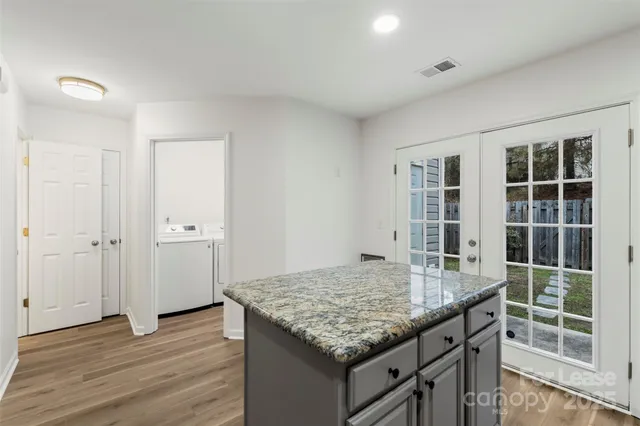 an outdoor kitchen with granite countertop window and wooden floor