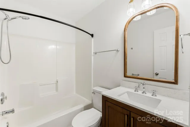a bathroom with a sink and mirror with bathtub