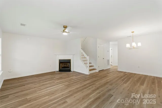 an empty room with wooden floor and fireplace