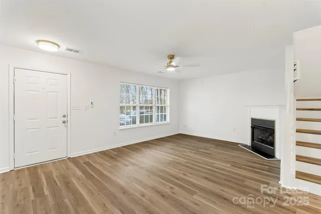 a view of an empty room with a fireplace and a window
