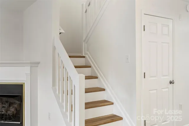 a view of staircase with white walls and white door
