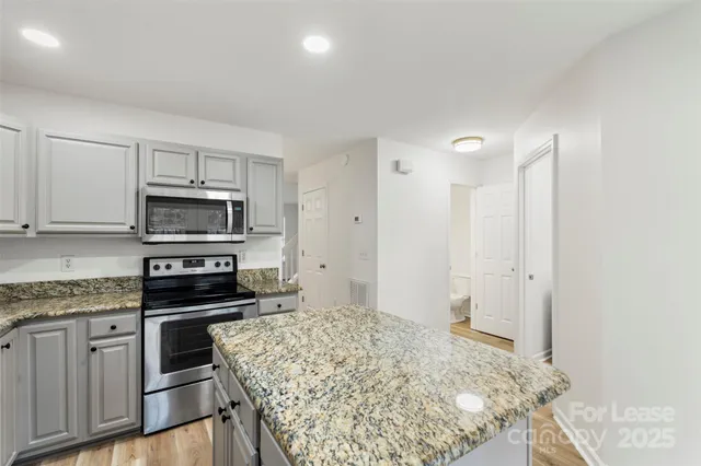 a kitchen with stainless steel appliances granite countertop a stove a sink and a refrigerator