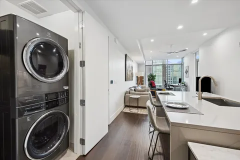 a living room with furniture a rug and a view of kitchen