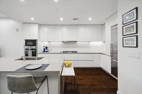 a kitchen with a sink cabinets and wooden floor