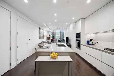 a kitchen with stainless steel appliances granite countertop a sink a stove and a refrigerator