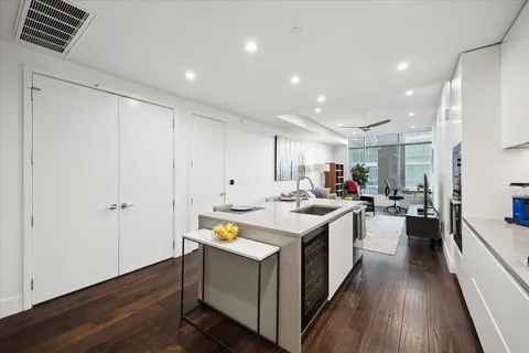 a kitchen with a sink and wooden floor