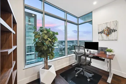 a view of a workspace with furniture and a window