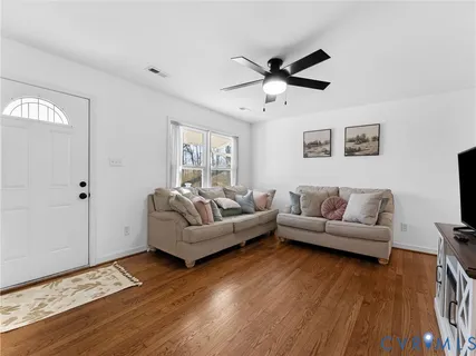 a living room with furniture and a wooden floor