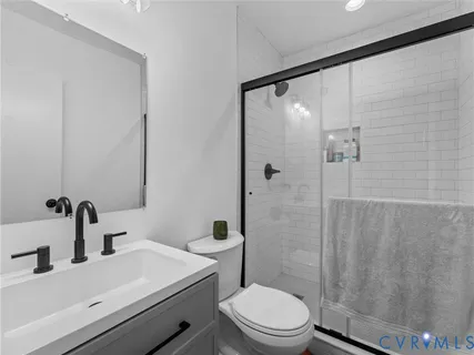 a bathroom with a sink a toilet and shower