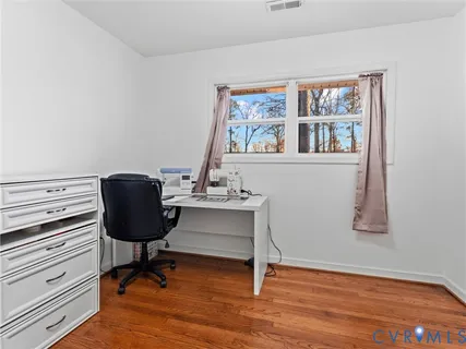 a view of a workspace with furniture and a window
